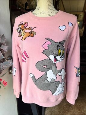 Woman’s light pink crewneck sweatshirt embroidered graphics of Tom and Jerry.